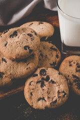 fresh healthy milk and cookies on dark wood background