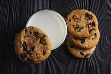 fresh healthy milk and cookies on dark wood background