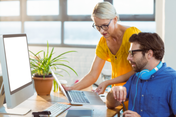Graphic designers discussing over laptop