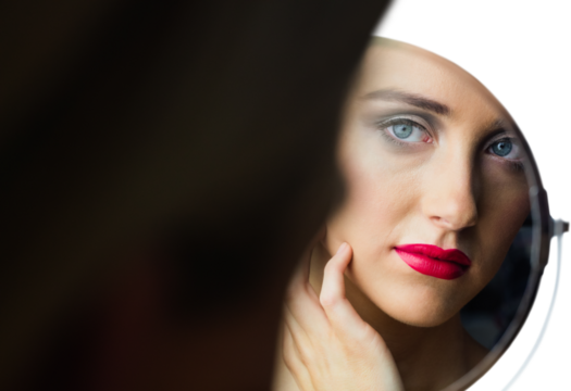 Woman with makeup looking into mirror