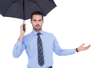 Serious businessman holding umbrella with arm out