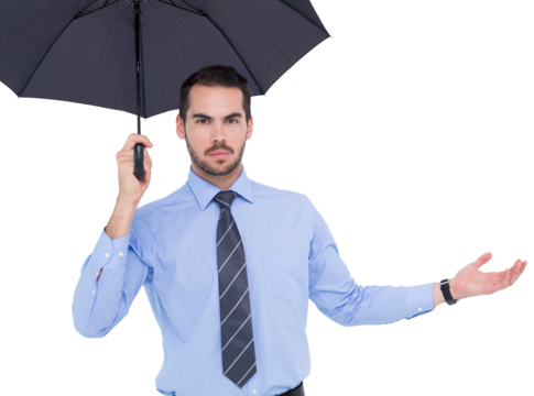Serious businessman holding umbrella with arm out