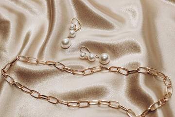 Women's jewelry, gold chain, trendy jewelry on a silk background.