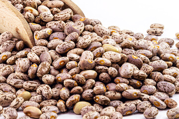 pile of Rajado beans, brazilian beans, with wooden measuring spoon, copy space, macro photography