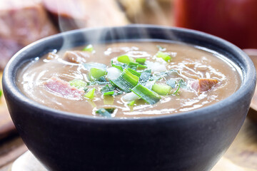 Brazilian bean broth, homemade bean soup served warm in winter, with ingredients in the background, macro photography