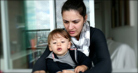 Mother and toddler child looking at cellphone screen