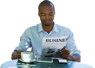 Businessman reading newspaper at table