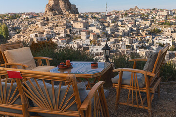 view from a street cafe with wooden chairs and tables on an ancient earthen city in Cappadocia, Turkey - 588486930