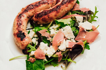 Salad with feta cheese with arugula and fried sausage.