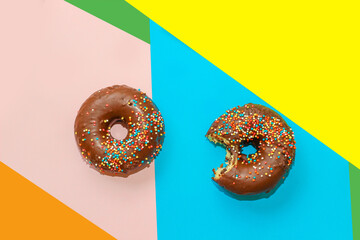 Glazed donut on a paper multi-colored background.