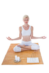 Fit woman meditating on bamboo mat