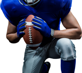 Mid section of American football player kneeling while holding ball