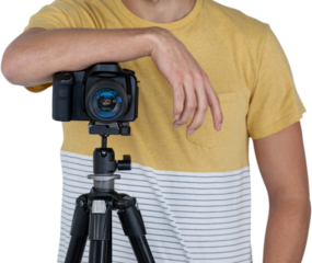 Mid section of photographer standing with camera on tripod