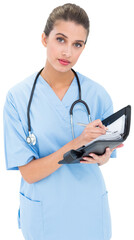 Stern brown haired nurse in blue scrubs filling an agenda
