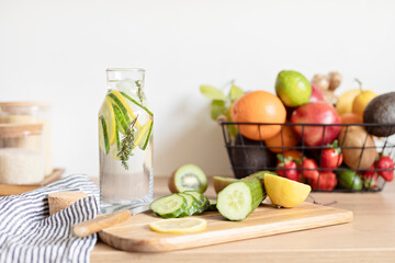 Infused  water with cucumber, lemon and thyme in glass bottle on wooden table. Diet, detox, healthy eating, weight loss concept