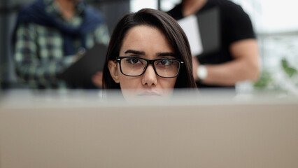 Confident businesswoman wearing casual clothes while sitting at office and working