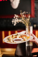 waiter holding cheese set with  jam, fruit and nuts