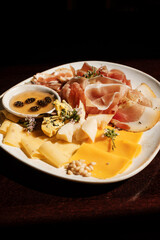 cheese set with  jam, fruit and nuts in sunlight