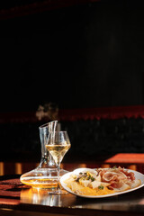decanter and a glass of wine. cheese set with  jam, fruit and nuts