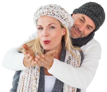 Husband hugging wife from behind as she blows kiss in air