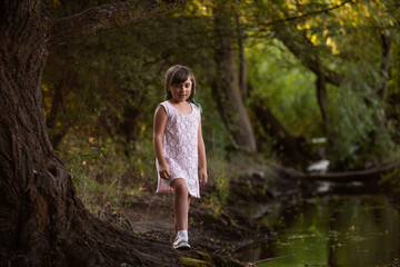 Teenage girl fooling around near small river, stream. Diversity child generation Z with green hair