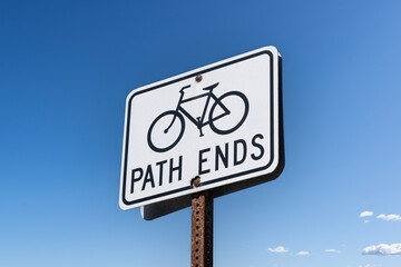 Bicycle path ends sign with blue sky background.