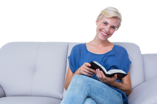 Attractive blonde woman reading a book on the couch