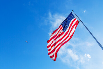 American Flag blowing in the wind with a blue sky background. USA American Flag. Waving United...