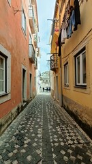 A narrow alley in Lisbon where people walk