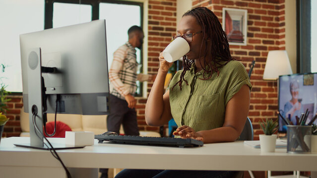Business student using computer at home with boyfriend, doing remote work to analyze company report. Woman sitting in living room and browsing internet on pc, corporate web app.