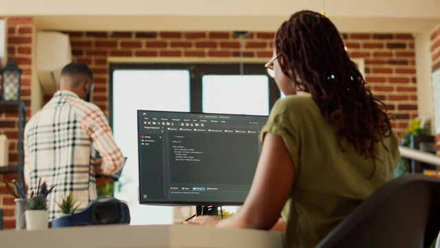 Female programmer using code to develop online app, working with html script on terminal window to program database software. IT manager planning artificial intelligence network. Handheld shot.