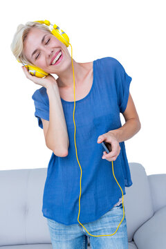 Cheerful woman listening music with her mobile phone