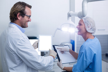 Dentist and dental assistant working on digital tablet