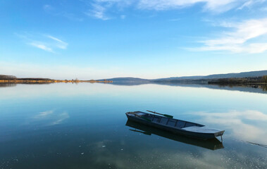 Fototapeta na wymiar Serbian border with Romania on the Danube river coastline panorama and a small fishing boat