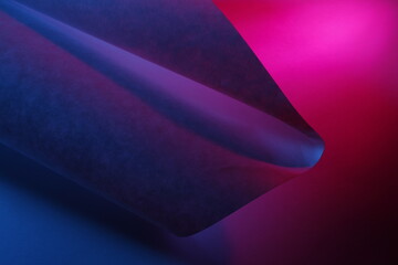 Papel para dibujo  con pliegues que forman un cono triangular en punta con líneas y  curvas de luz rosa y azul, presenta un hermoso y original diseño abstracto con fondo bokeh