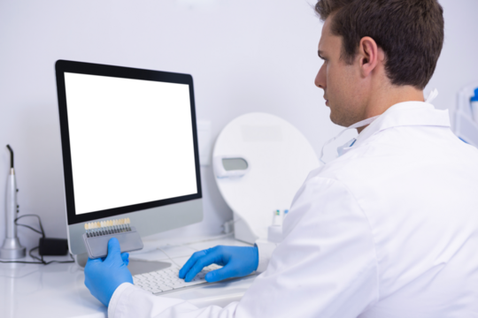 Dentist working on computer against wall