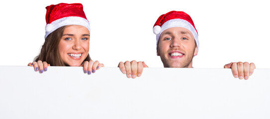 Couple in santas hats with blank board