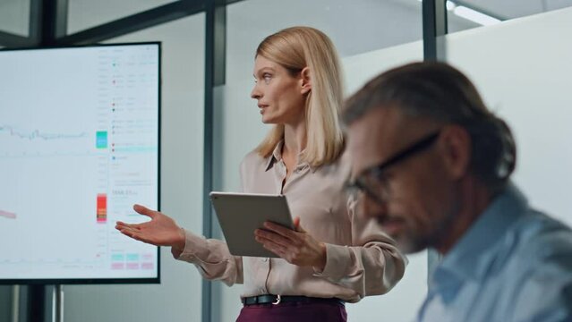 Inspired woman pointing screen in office close up. Female speaker mentoring team