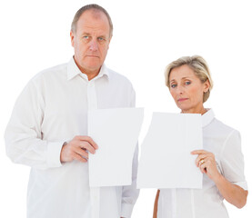 Upset couple holding torn piece of paper 