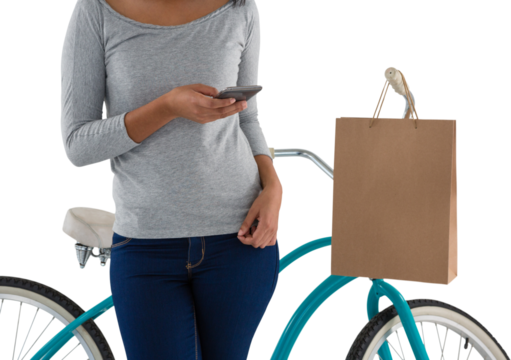 Woman using mobile phone while standing by bicycle - Powered by Adobe