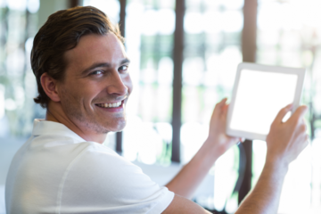 Man holding digital tablet at cafe