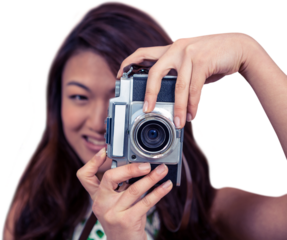 Smiling Asian woman taking photograph with camera