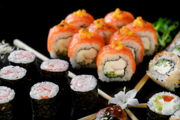 Sushi set on a black background. Fresh variety of rolls in a Japanese restaurant. Eastern cuisine.