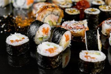 Sushi set on a black background. Fresh variety of rolls in a Japanese restaurant. Eastern cuisine.