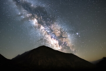 Night sky filled with stars and milky way above mountain