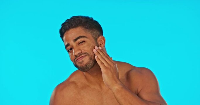 Face, skincare smile and man with serum in studio isolated on a blue background. Hair care, dermatology cosmetics and happy Indian male model with hyaluronic acid, retinol or essential oil for beard.