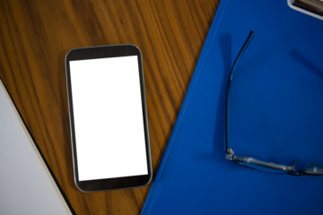 High angle view of phone and clipboard on table