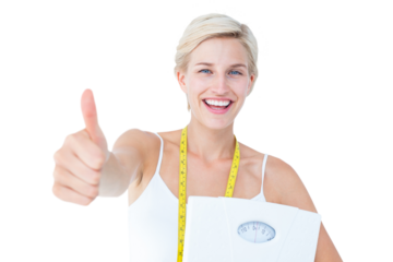 Happy woman holding scales with thumbs up