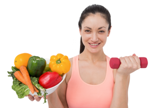 Fit brunette lifting dumbbell and holding bowl of salad