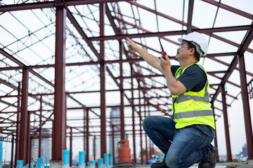 Worker in a construction site. Architecture engineering holding a laptop on building site checking plans. Successful engineer or architect, Joyous businessman